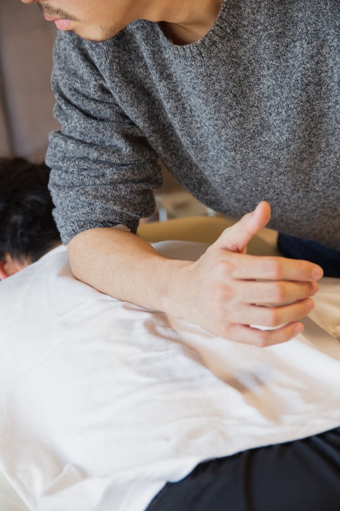 Man doing massage to patient lying on couch